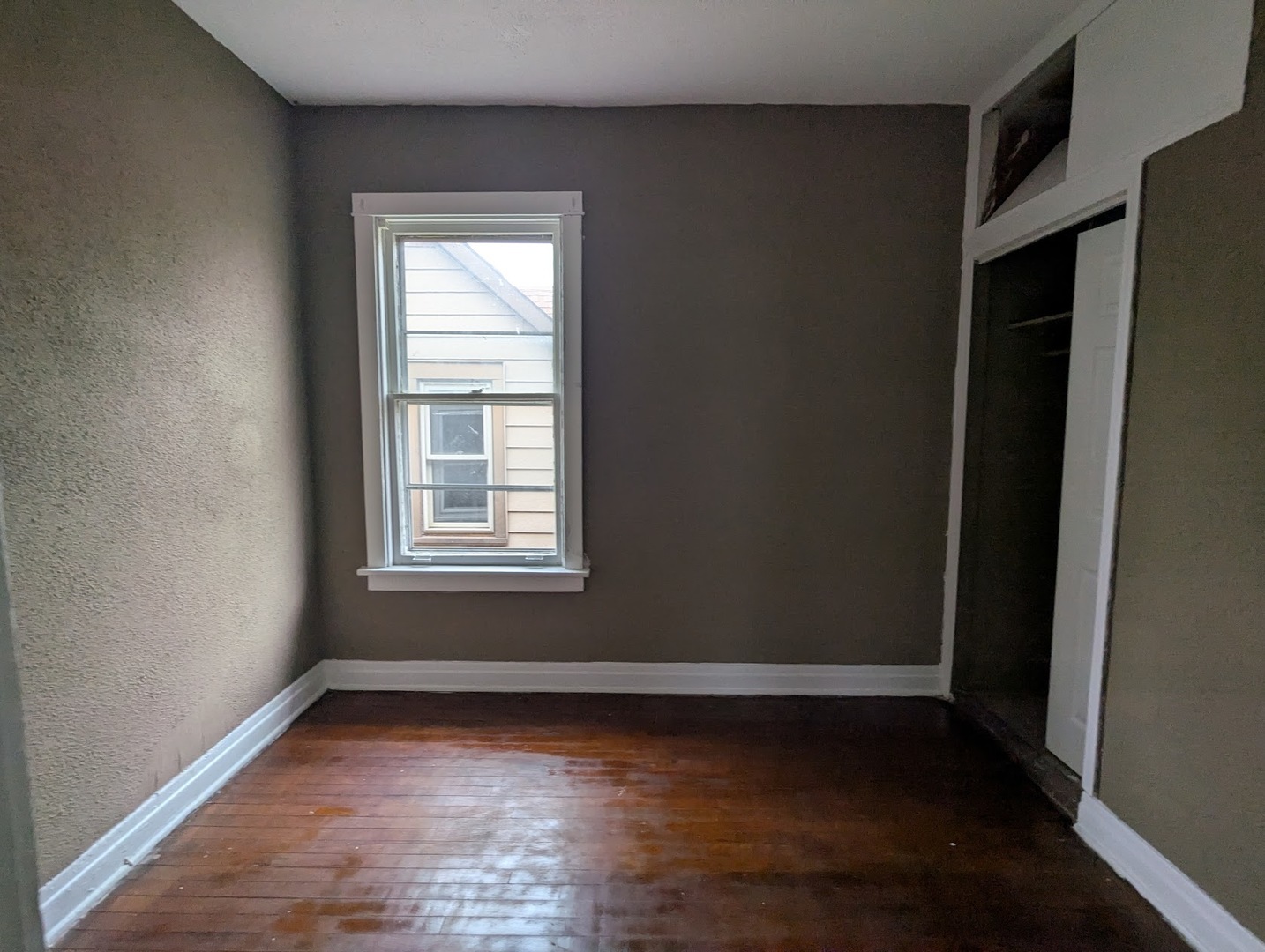 324 West 112th Street Chicago, IL 60628 - Photo 14 of 17 a view of an empty room with wooden floor and a window
