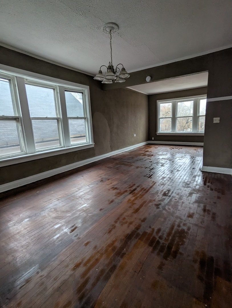 324 West 112th Street Chicago, IL 60628 - Photo 5 of 17 a view of an empty room with wooden floor and a window