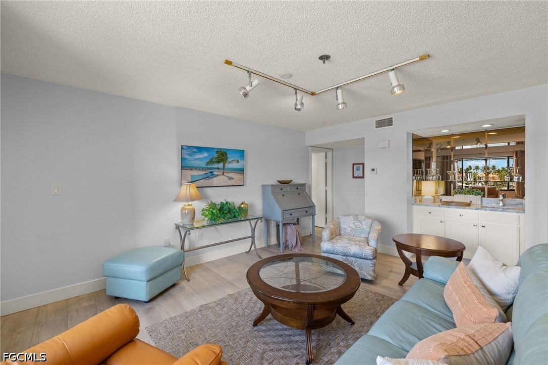 3170 Matecumbe Key Road, Unit 134 Punta Gorda, FL 33955 - Photo 5 of 31 a living room with furniture a rug and a chandelier