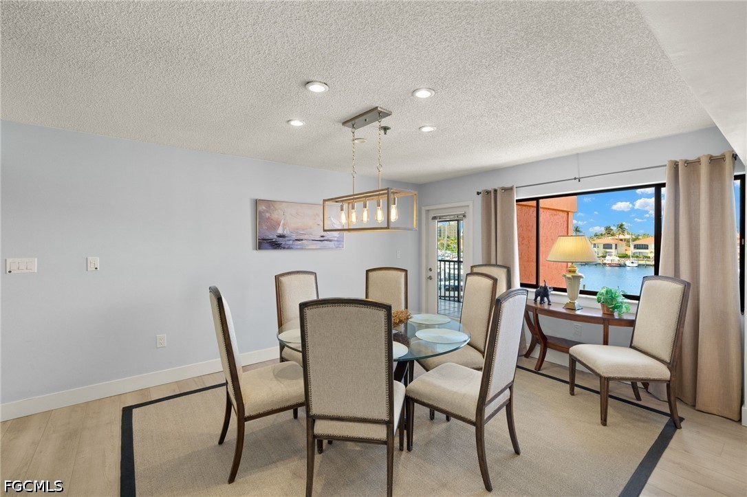 3170 Matecumbe Key Road, Unit 134 Punta Gorda, FL 33955 - Photo 7 of 31 a view of a dining room with furniture a rug and wooden floor