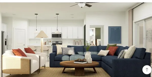 a living room with furniture kitchen view and a chandelier