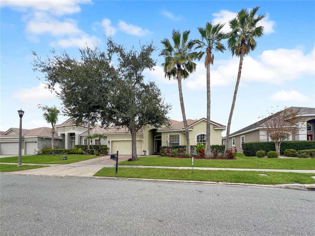 11531 Vicolo Loop Windermere, FL 34786 - Photo 18 of 32 a view of a white house with a big yard and palm trees