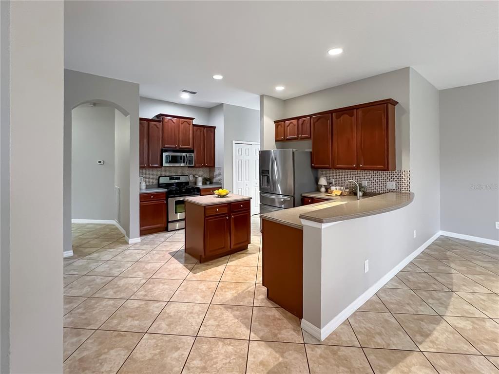 11531 Vicolo Loop Windermere, FL 34786 - Photo 2 of 32 a kitchen with stainless steel appliances a stove a sink a microwave a counter top space and cabinets