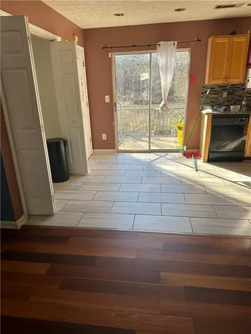 a view of an empty room with a fireplace and a window