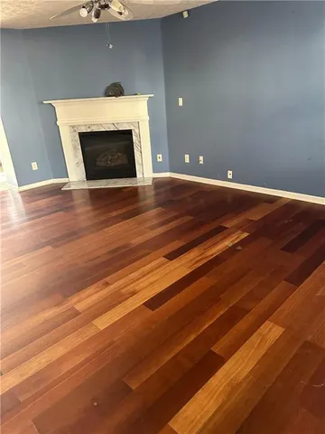 a view of empty room with wooden floor and fireplace