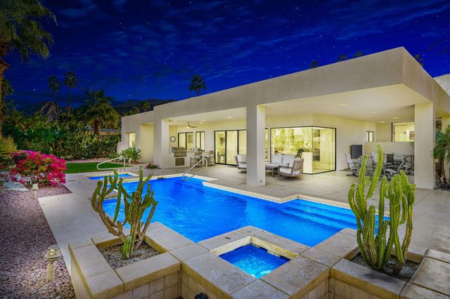 a living room with furniture pool table and a potted plant