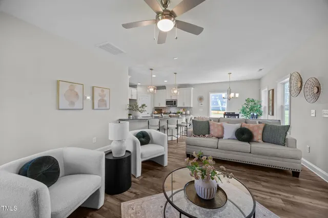 a living room with furniture a fireplace and wooden floor