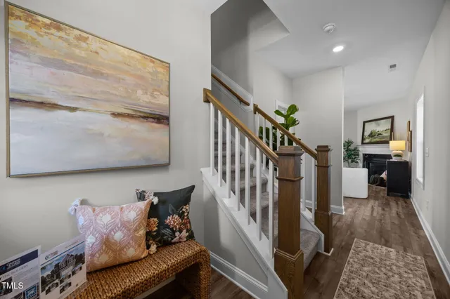 a kitchen with stainless steel appliances kitchen island granite countertop a dining table chairs and a refrigerator