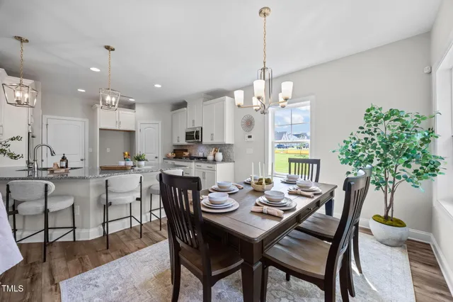 a dining room with furniture a chandelier and wooden floor