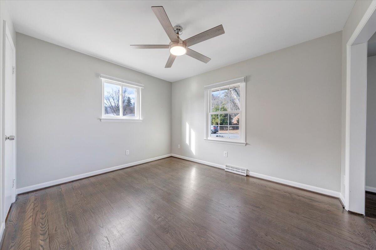 3804 Meadowlark Road Roanoke, VA 24018 - Photo 12 of 54 an empty room with wooden floor ceiling fan and windows