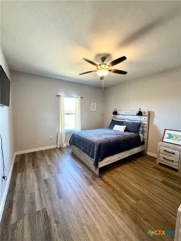 a bedroom with a bed and wooden floor