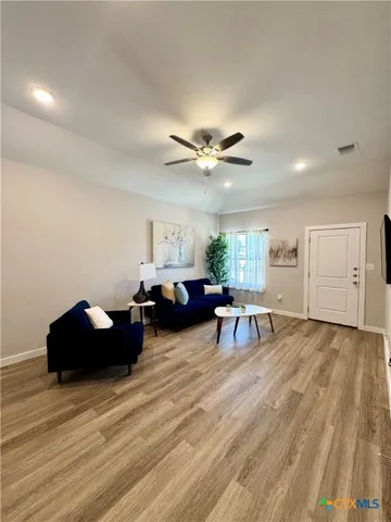 a living room with furniture and a wooden floor