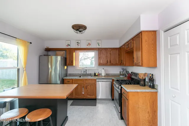 a kitchen with blue cabinets a sink dishwasher and a stove with wooden floor