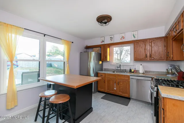 a kitchen with granite countertop a stove a sink and a refrigerator