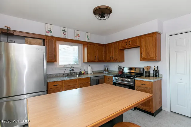 a kitchen with granite countertop a refrigerator stove top oven and sink