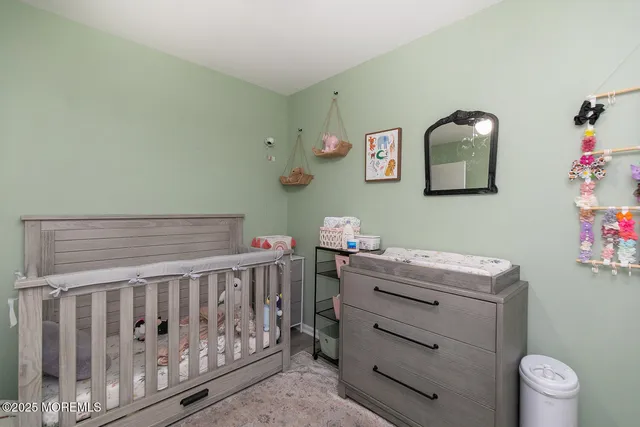 a bedroom with a baby bed with the wooden floor
