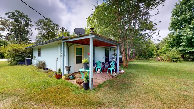 a backyard of a house with table and chairs