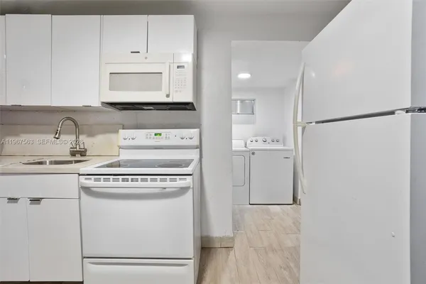 a kitchen with a refrigerator sink stove and cabinets