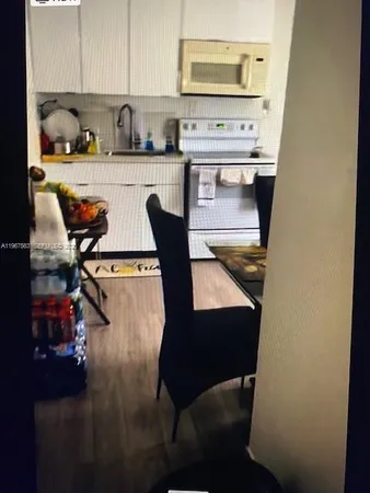 a kitchen with a table chairs stove and cabinets