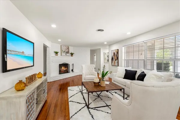 a living room with furniture and a fireplace with wooden floor