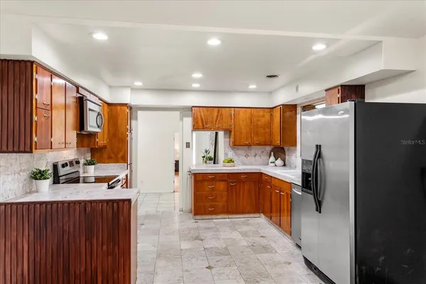 a large kitchen with stainless steel appliances lots of counter top space