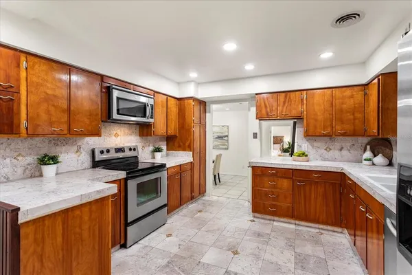 a kitchen with stainless steel appliances granite countertop wooden cabinets a stove top oven a sink and dishwasher