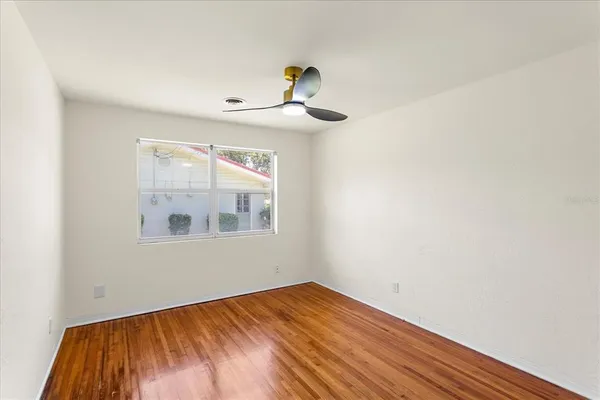 a view of empty room with wooden floor