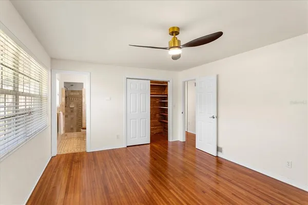a view of empty room with wooden floor and window
