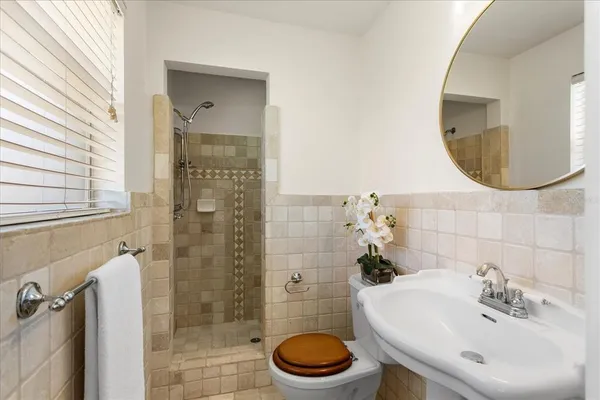 a bathroom with a sink a toilet and a mirror