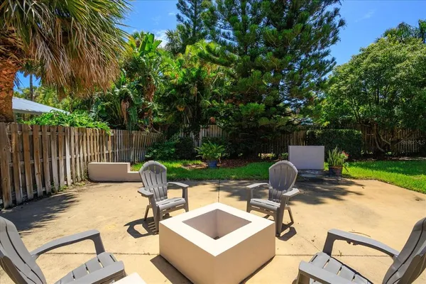 a view of a patio with a table chairs and a fire pit