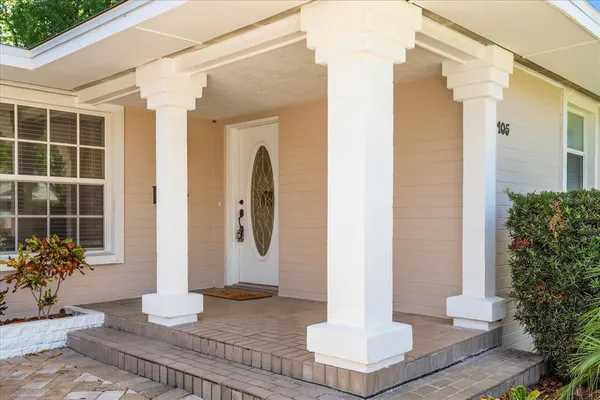 a front view of a house with potted plants
