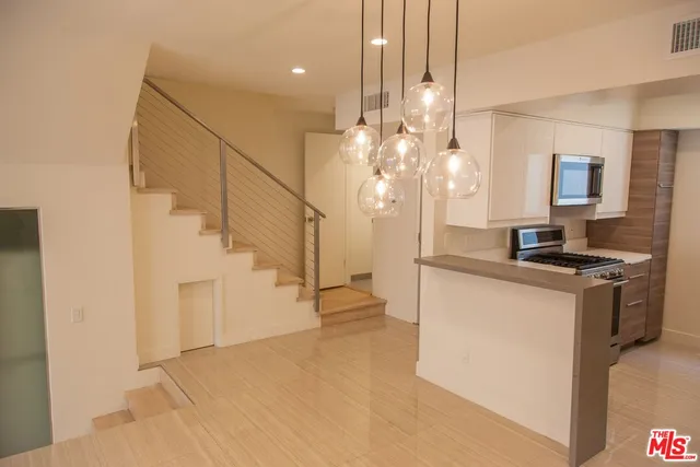 a view of a kitchen with a sink and a refrigerator