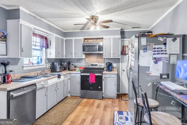 a kitchen with stainless steel appliances granite countertop a stove refrigerator and a sink