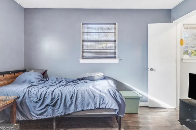 a bedroom with bed and wooden floor