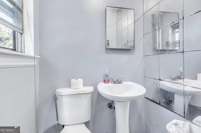 a bathroom with a sink toilet and a mirror