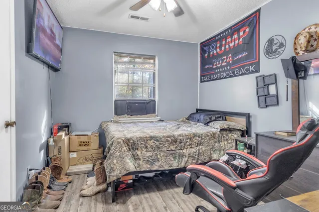 a bedroom with a bed a couch and a chandelier