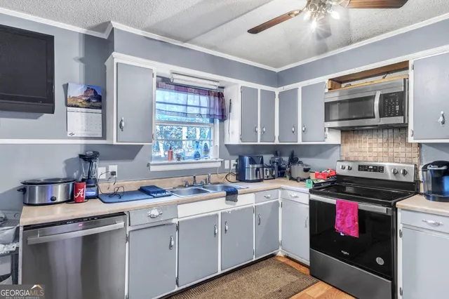 a kitchen with stainless steel appliances a stove sink microwave and cabinets