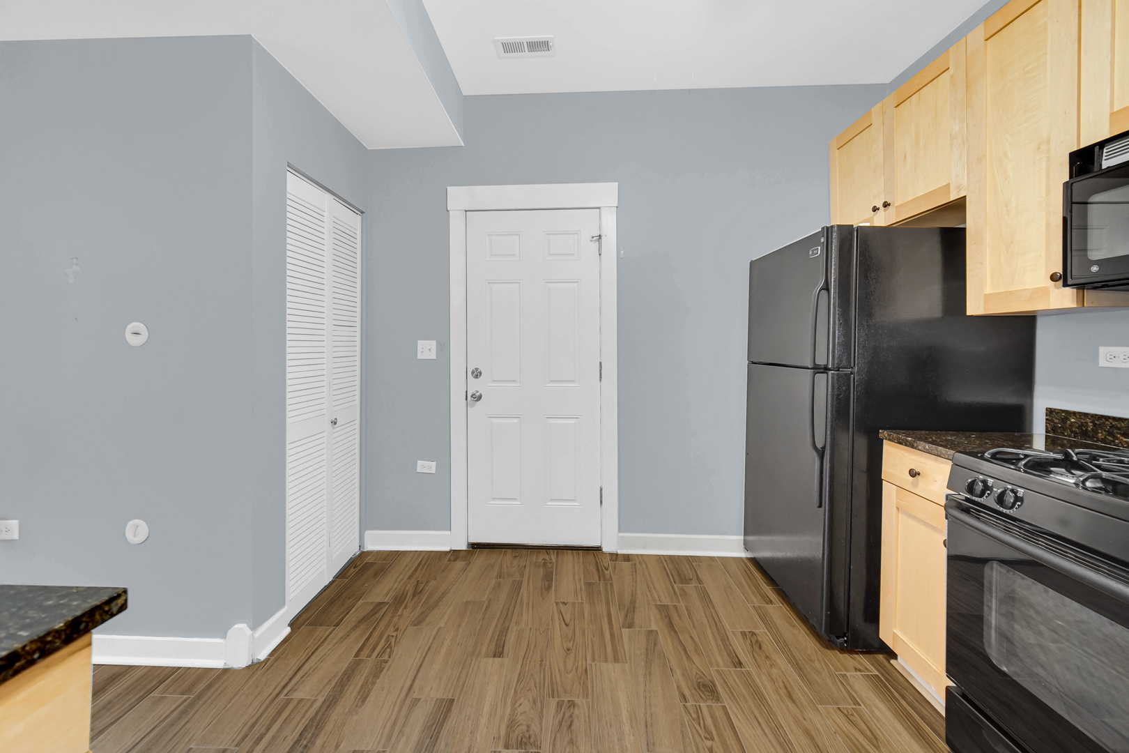 4343 North Sacramento Avenue, Unit AG Chicago, IL 60618 - Photo 14 of 27 a kitchen with a refrigerator stove and wooden floor
