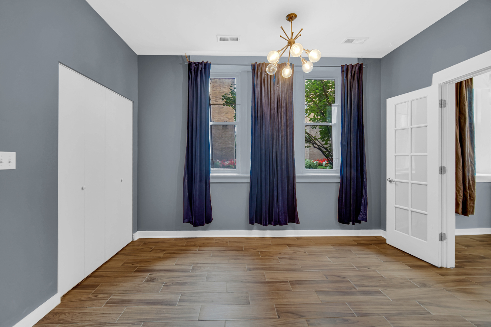 4343 North Sacramento Avenue, Unit AG Chicago, IL 60618 - Photo 19 of 27 an empty room with wooden floor chandelier fan and hallway