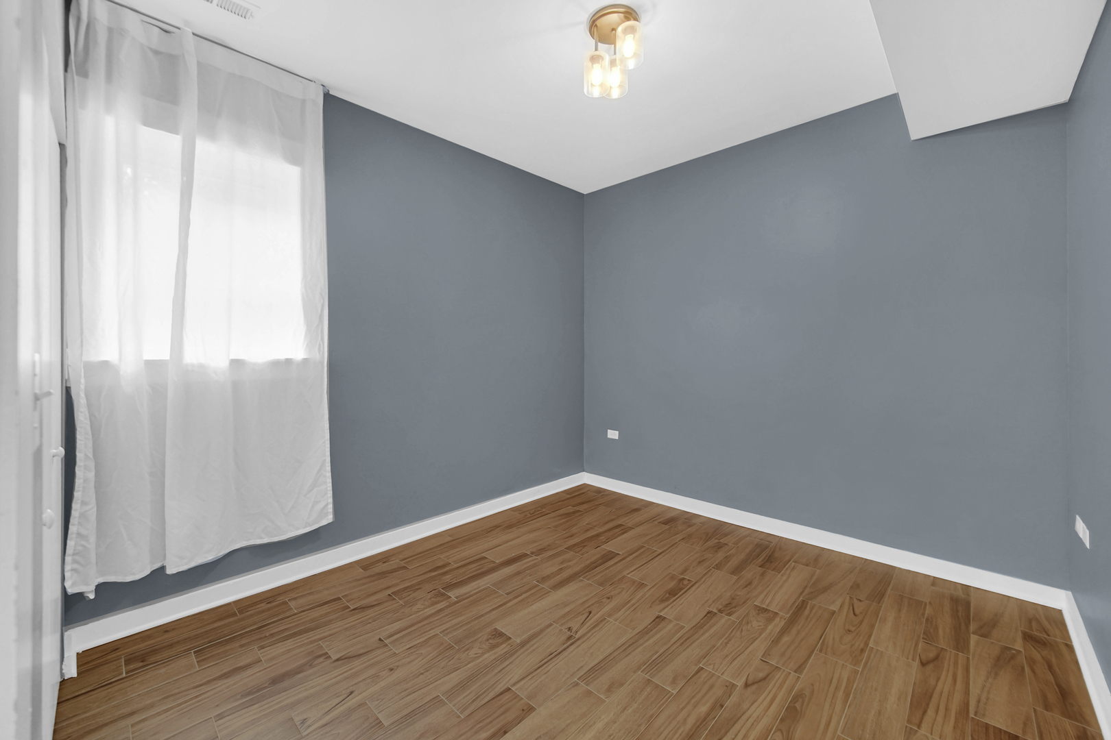 4343 North Sacramento Avenue, Unit AG Chicago, IL 60618 - Photo 24 of 27 an empty room with wooden floor and windows