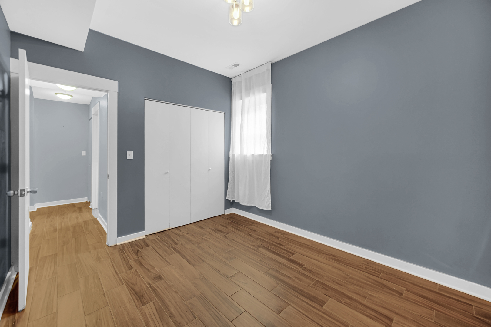 4343 North Sacramento Avenue, Unit AG Chicago, IL 60618 - Photo 25 of 27 a view of an empty room with wooden floor