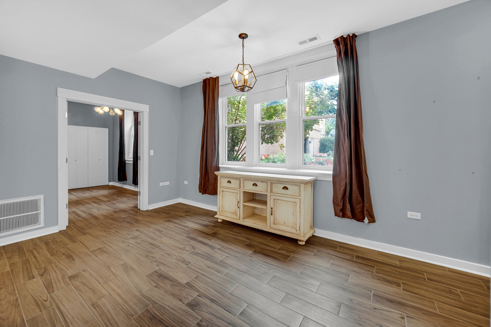 4343 North Sacramento Avenue, Unit AG Chicago, IL 60618 - Photo 7 of 27 a view of an empty room with wooden floor and a window