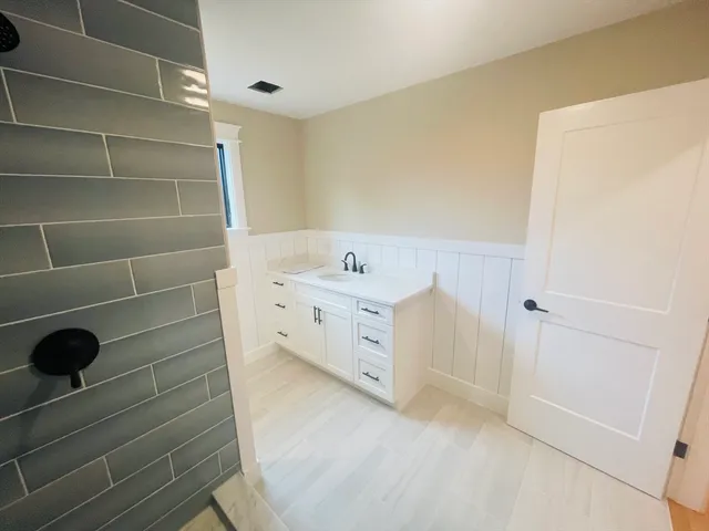 a bathroom with a bathtub sink vanity and mirror