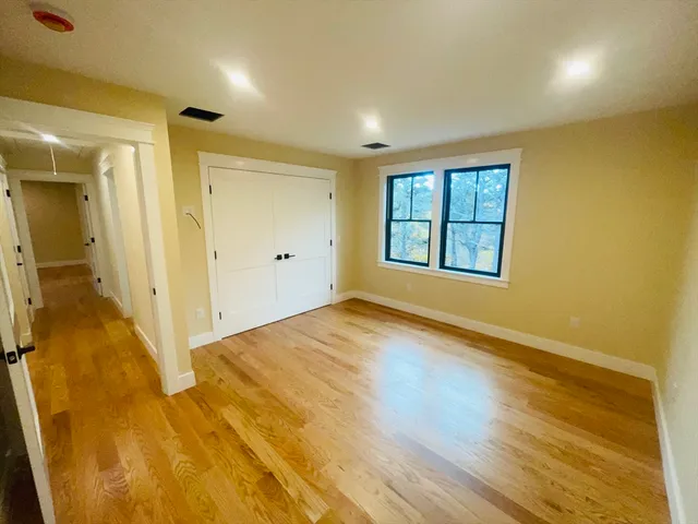 an empty room with wooden floor and a window
