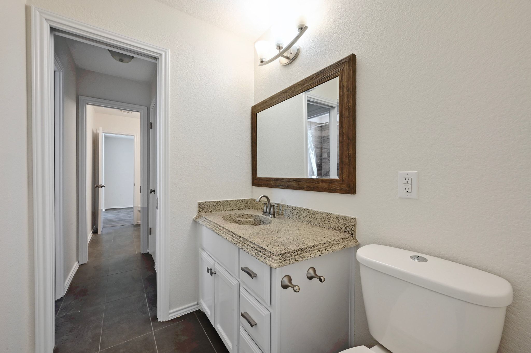 201 Comanche Camp Kyle, TX 78640 - Photo 18 of 37 a bathroom with a granite countertop toilet sink and mirror