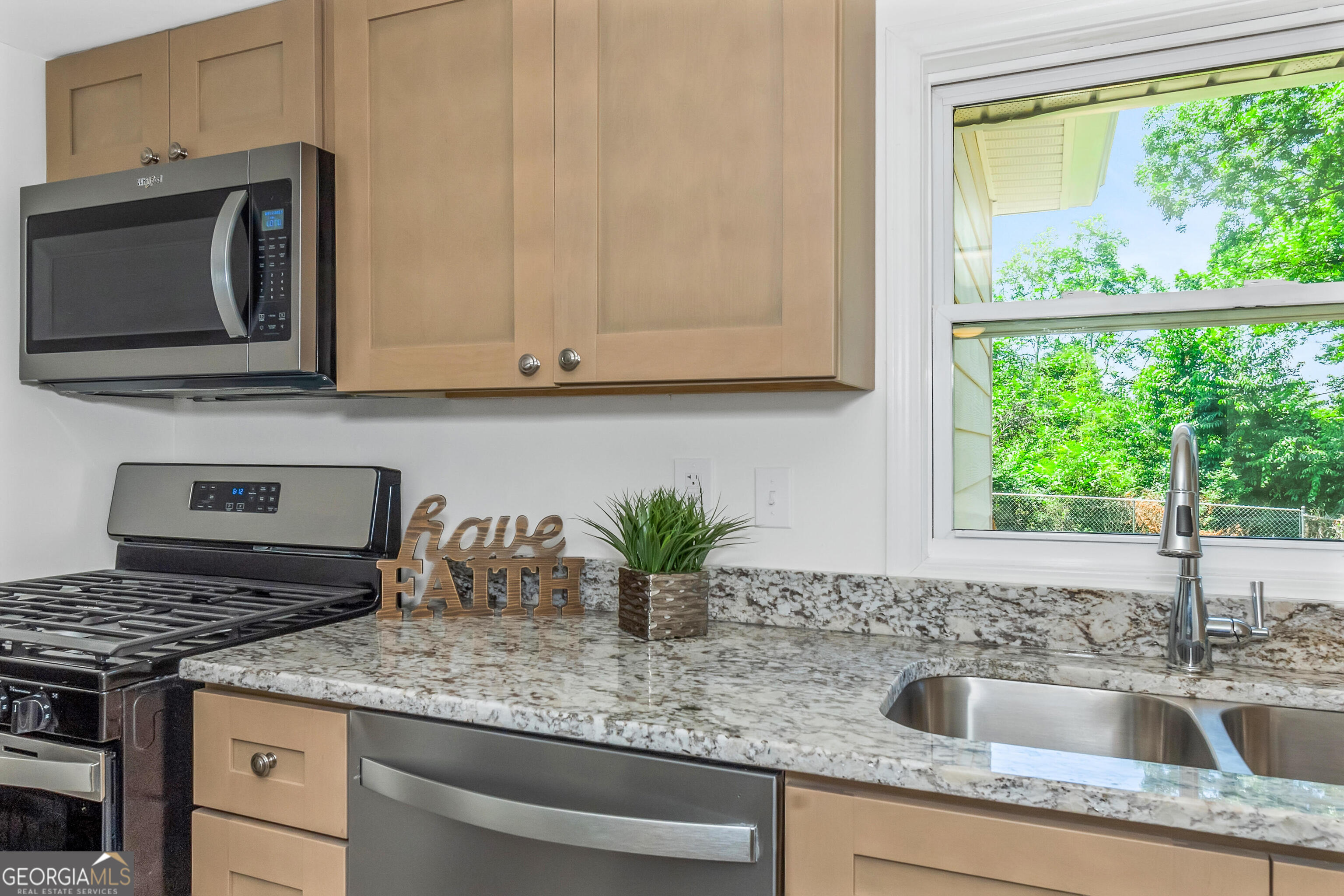 204 Mill Street Barnesville, GA 30204 - Photo 15 of 35 a kitchen with stainless steel appliances granite countertop a sink a stove and a microwave