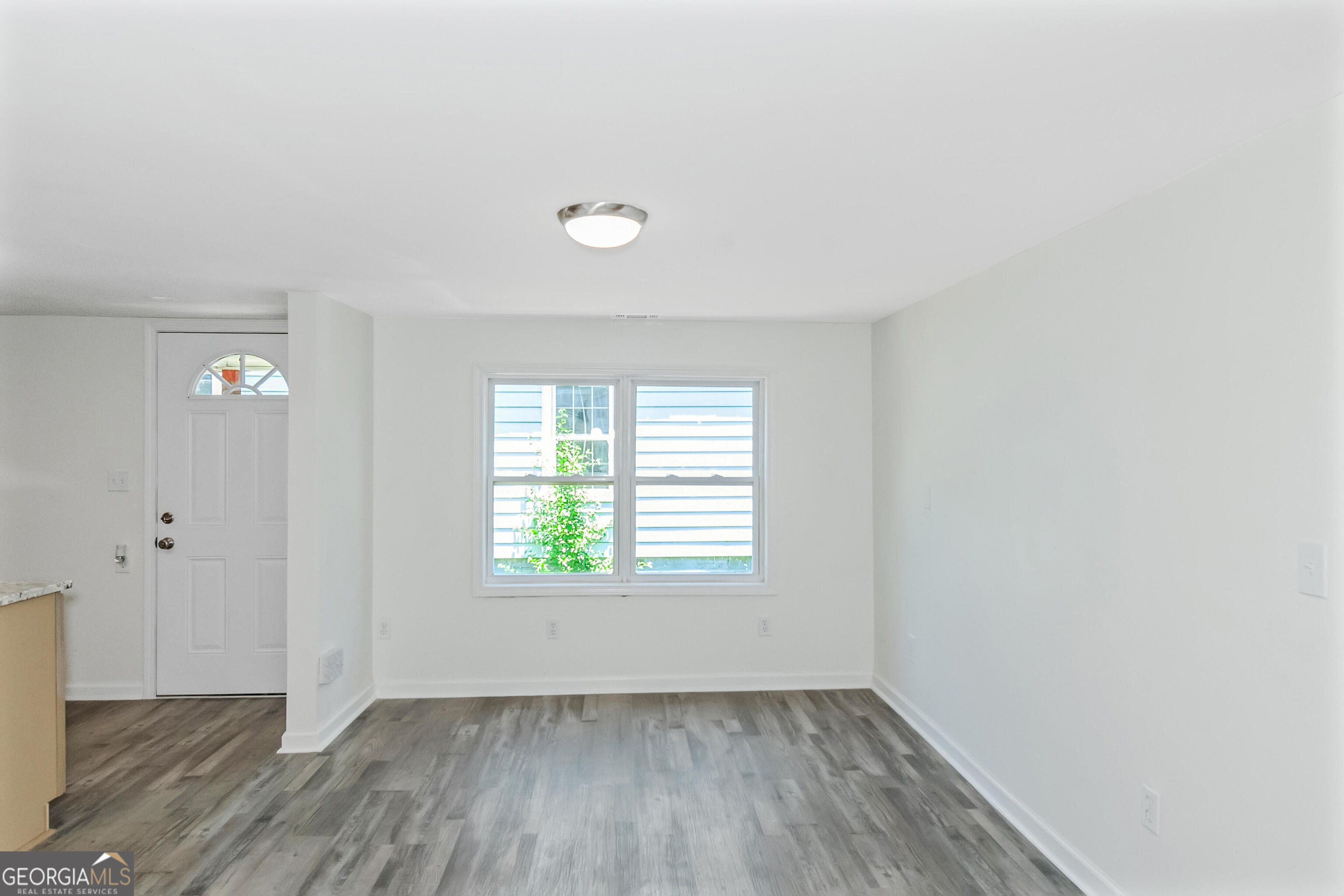 204 Mill Street Barnesville, GA 30204 - Photo 7 of 35 an empty room with wooden floor and windows