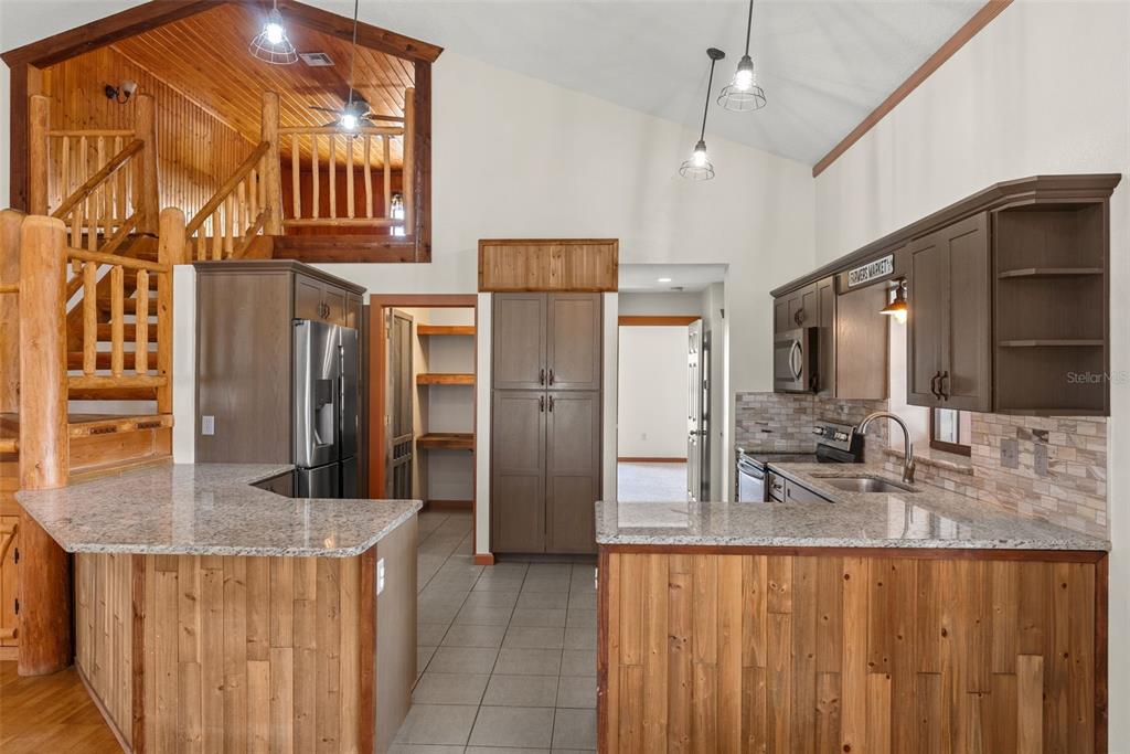 17620 North Poyner Road Polk City, FL 33868 - Photo 15 of 46 a kitchen with stainless steel appliances granite countertop a sink and a refrigerator