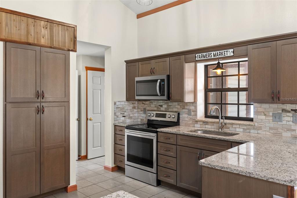 17620 North Poyner Road Polk City, FL 33868 - Photo 17 of 46 a kitchen with stainless steel appliances granite countertop a refrigerator and a sink