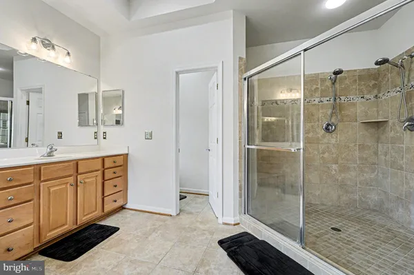 a spacious bathroom with a shower sink and mirror